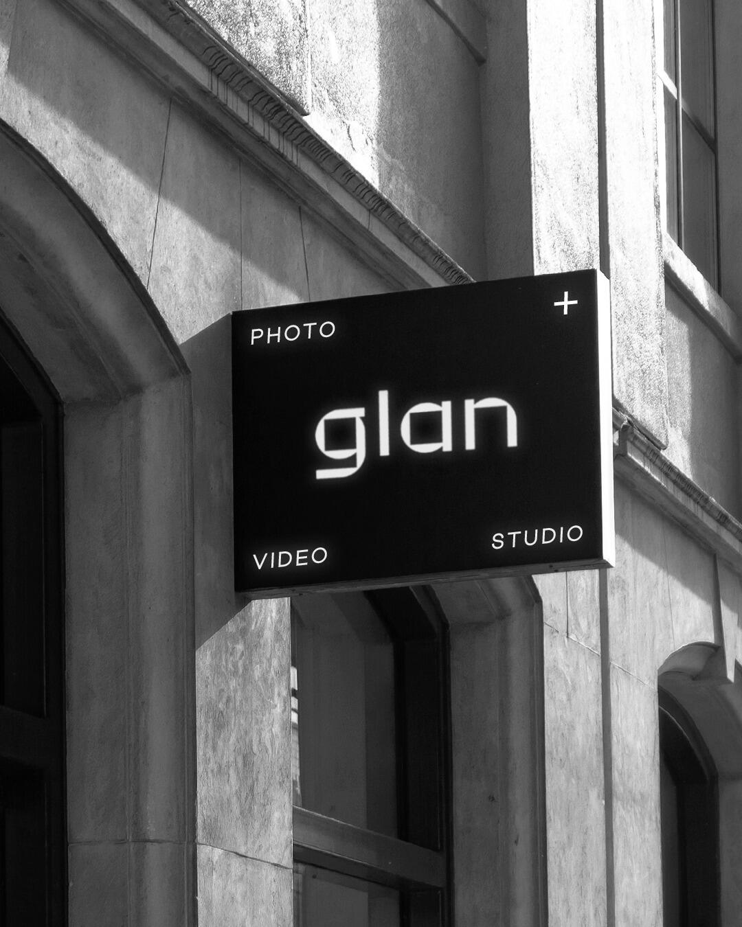 Világító fekete cégér a glan logóval épület homlokzatán fotósnak