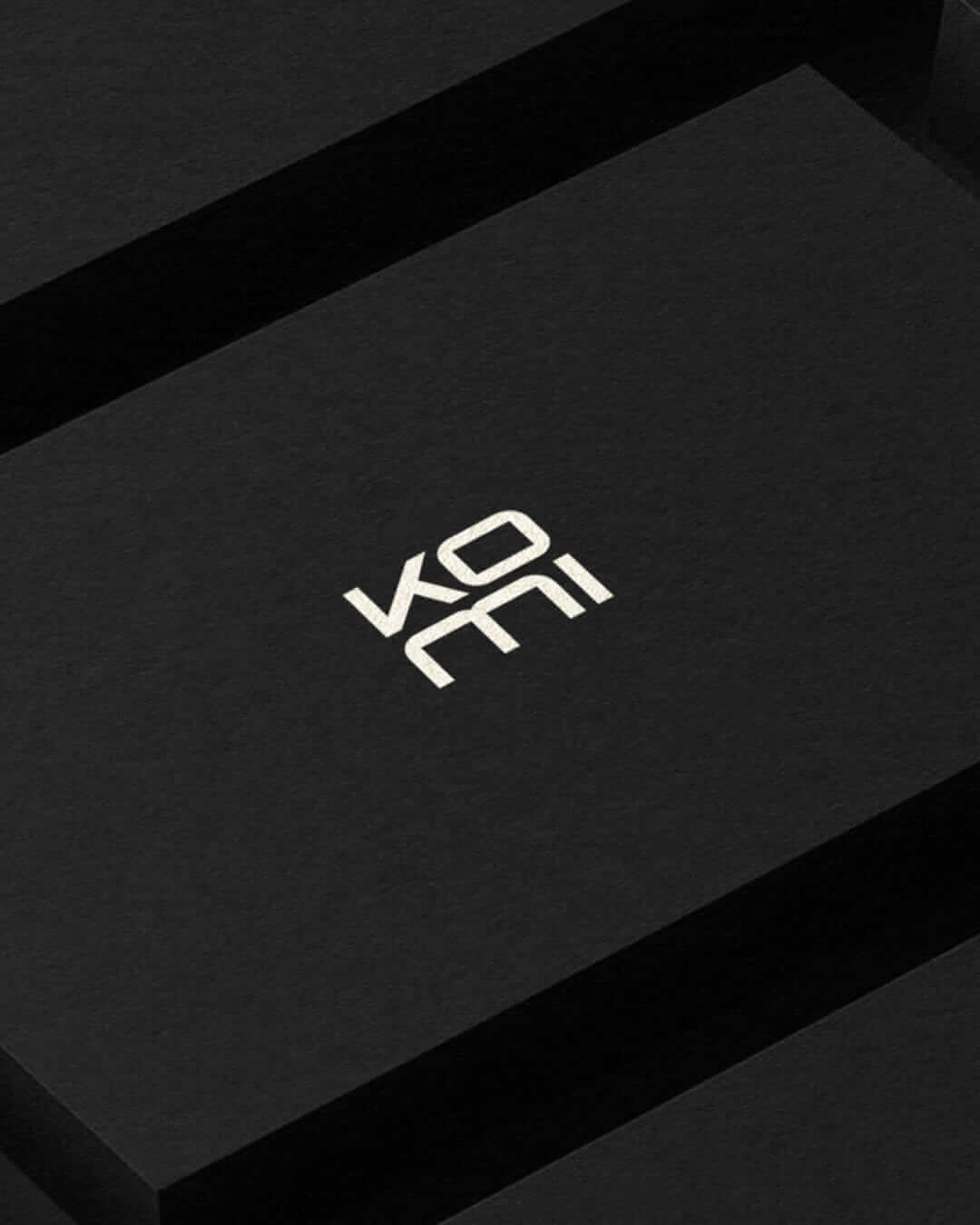 KOMI logó fekete felületen letisztult minimalista arculati megjelenésben